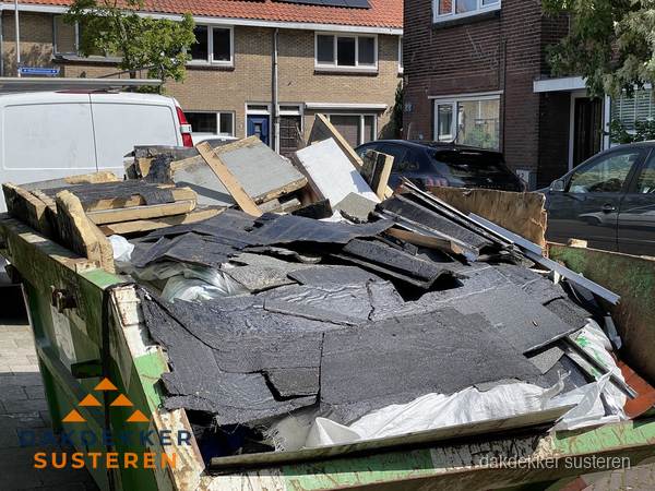 Afvalcontainer met gesloopt dakmateriaal tijdens dakkapel renovatie in Susteren