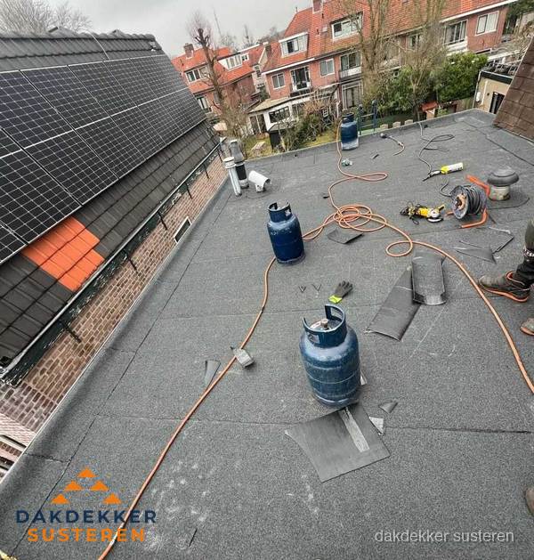 Daklekkage repareren met brandgereedschap op plat dak in Susteren