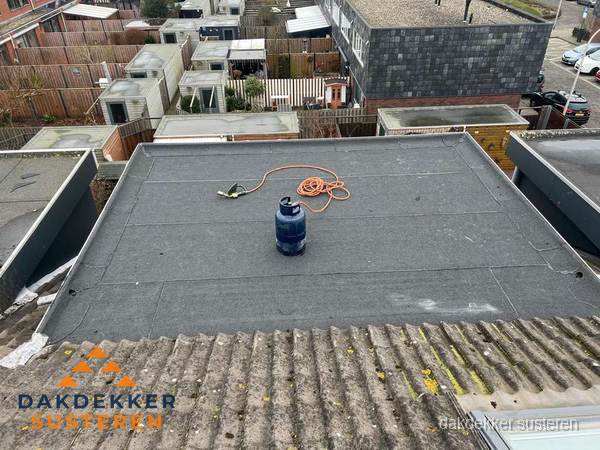 Plat dak met nieuwe bitumen dakbedekking en brandgereedschap in Susteren