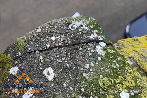Beschadigde en verweerde nokvorst met scheuren en mos in Susteren Beschadigde en verweerde nokvorst met scheuren en mos in Susteren