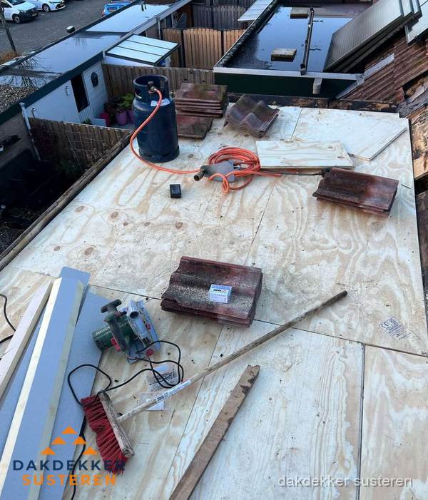 Dakreparatie werkzaamheden op plat dak met gereedschap in Susteren