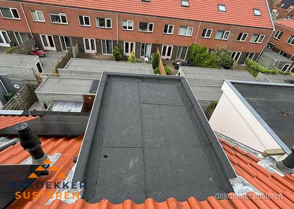 Plat dak met bitumen bedekking naast dakkapel in Susteren