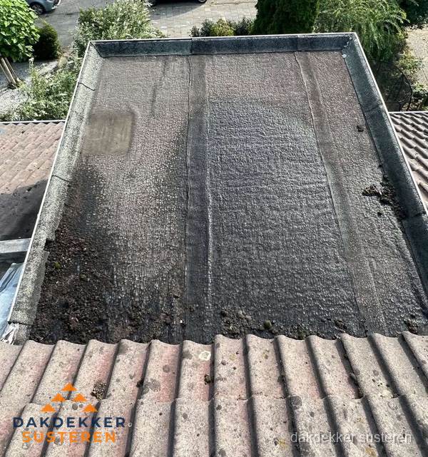 Verouderd plat dak met bitumen en slijtage voor lekkage inspectie in Susteren Verouderd plat dak met bitumen en slijtage voor lekkage inspectie in Susteren