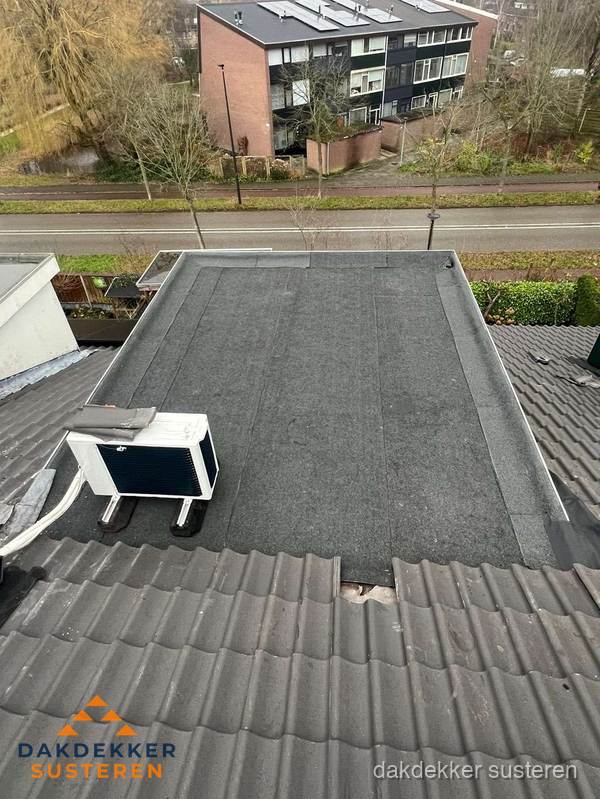 Plat dak inspectie met bitumen bedekking naast schuin pannendak in Susteren Plat dak inspectie met bitumen bedekking naast schuin pannendak in Susteren