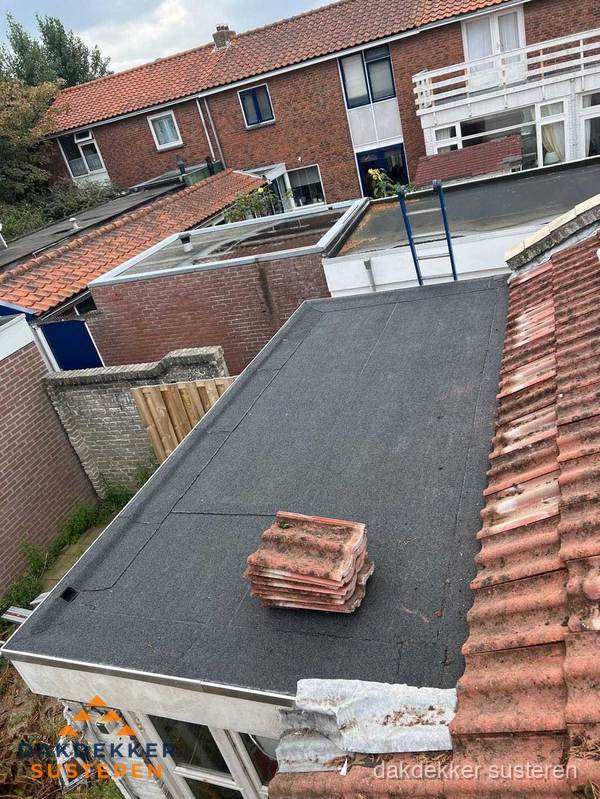 Plat dak aanbouw met bitumen naast schuin pannendak in Susteren Plat dak aanbouw met bitumen naast schuin pannendak in Susteren