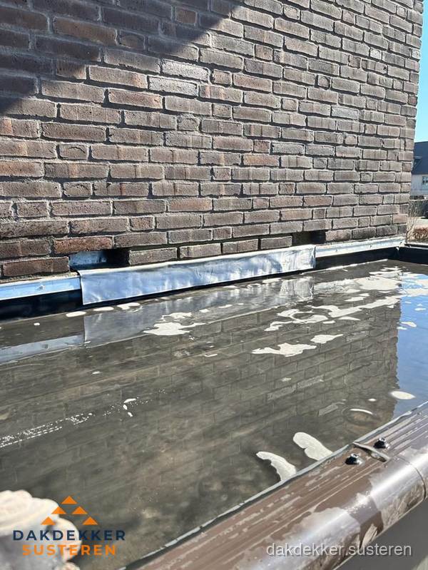 Stilstaand water op plat dak door slechte afwatering in Susteren Stilstaand water op plat dak door slechte afwatering in Susteren