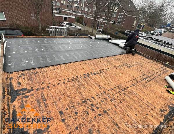 Dakdekker legt onderlaag op plat dak met houten constructie in Susteren
