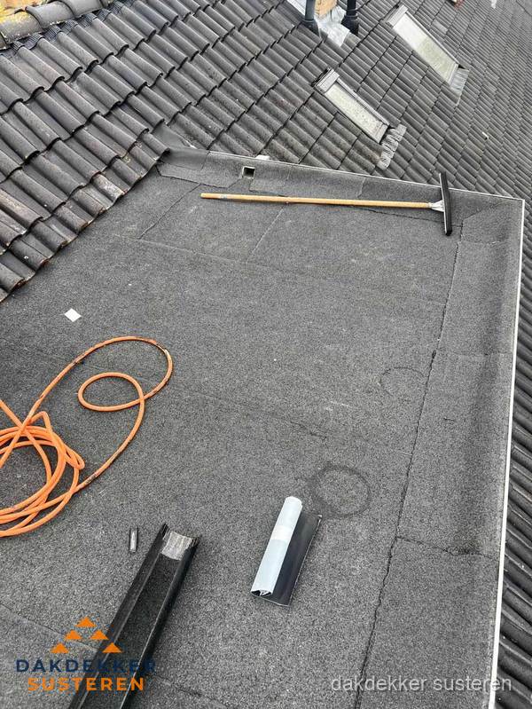 Plat dak reparatie met gereedschap en loodstroken in Susteren Plat dak reparatie met gereedschap en loodstroken in Susteren