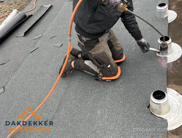 Dakdekker repareert bitumen dakleer bij dakdoorvoer in Susteren Dakdekker repareert bitumen dakleer bij dakdoorvoer in Susteren