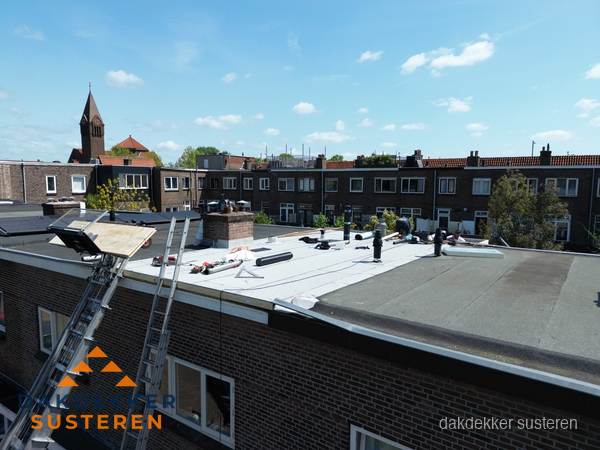 Dakdekkers aan het werk op plat dak in Susteren Dakdekkers aan het werk op plat dak in Susteren